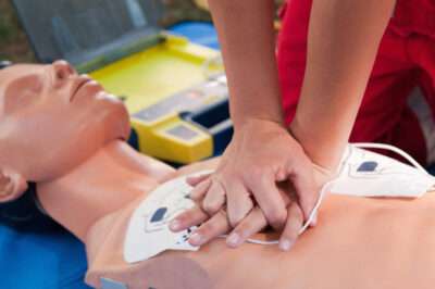 Practicing defibrillator CPR procedure on a dummy Practicing defibrillator CPR procedure on a dummy